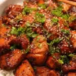 Delicious Crockpot Honey Garlic Chicken in a rustic bowl with herbs