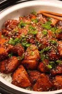 Delicious Crockpot Honey Garlic Chicken in a rustic bowl with herbs