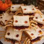 Peanut butter and jelly spider sandwiches with edible eyes on a plate