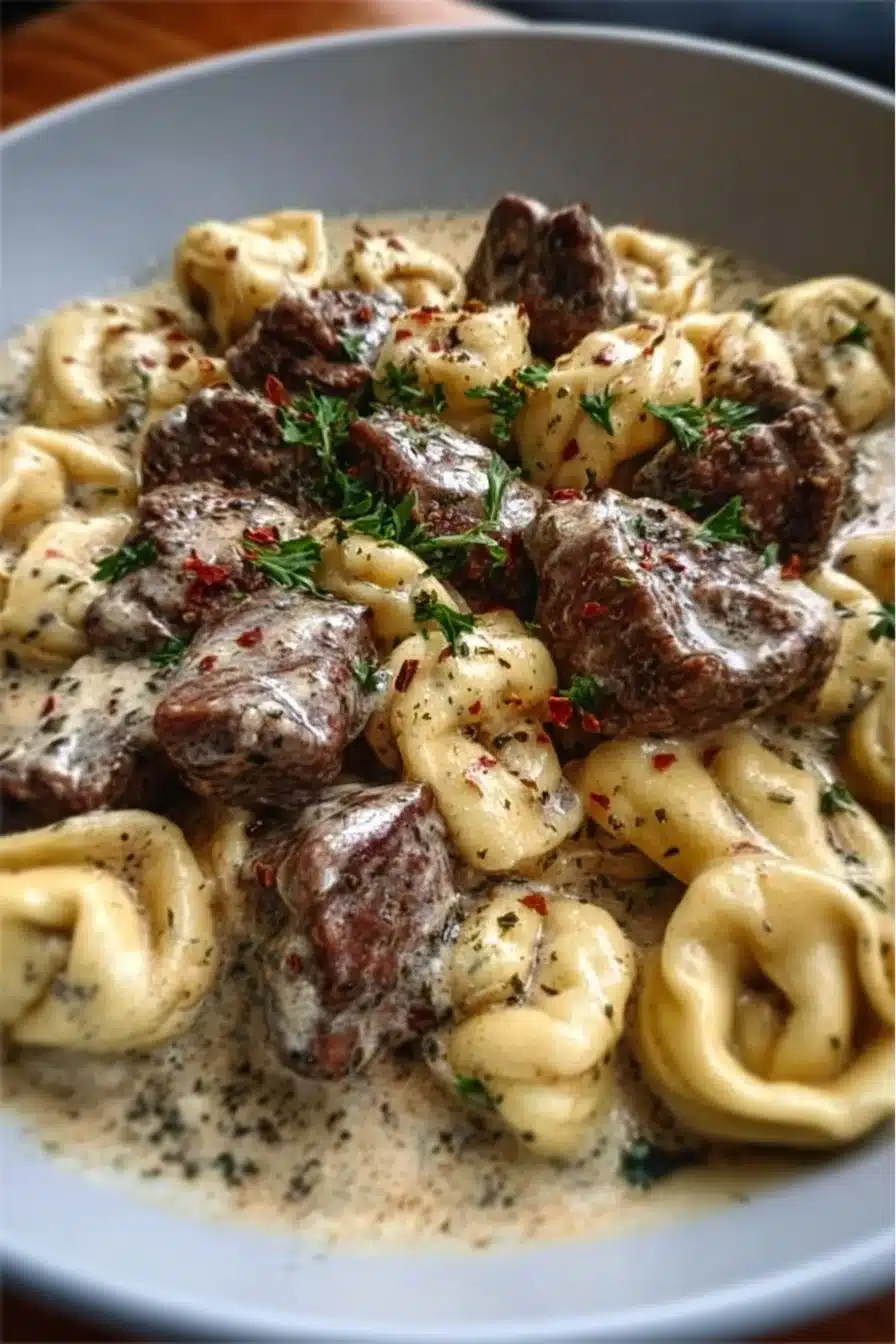 Delicious Garlic Steak Tortellini in creamy sauce, garnished with herbs.